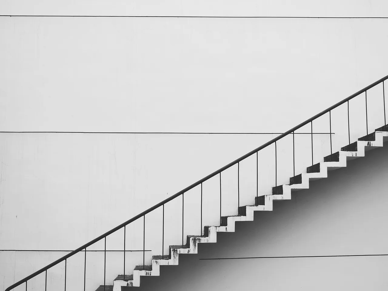 Escalier extérieur avec garde-corps le long d'un mur clair